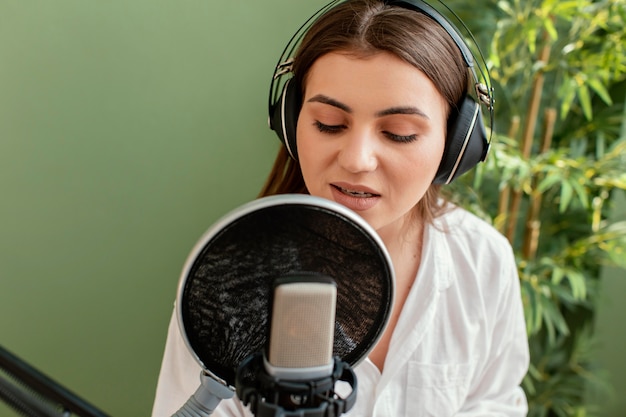 Front view of female musician playing piano keyboard and singing