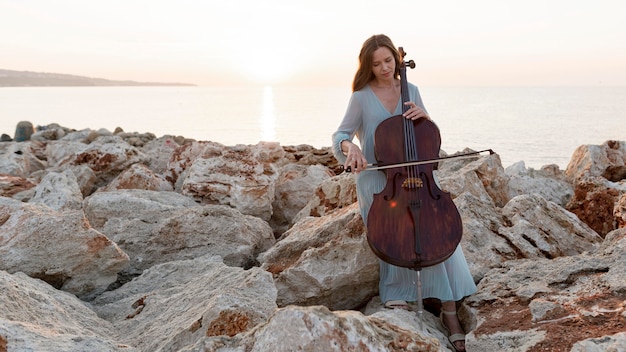 Front view of female musician with cello and copy space