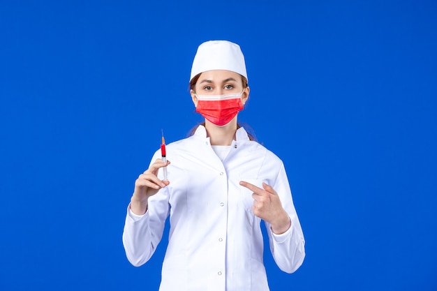 赤いマスクと青い手に注射をした白い医療スーツを着た正面図の女性看護師