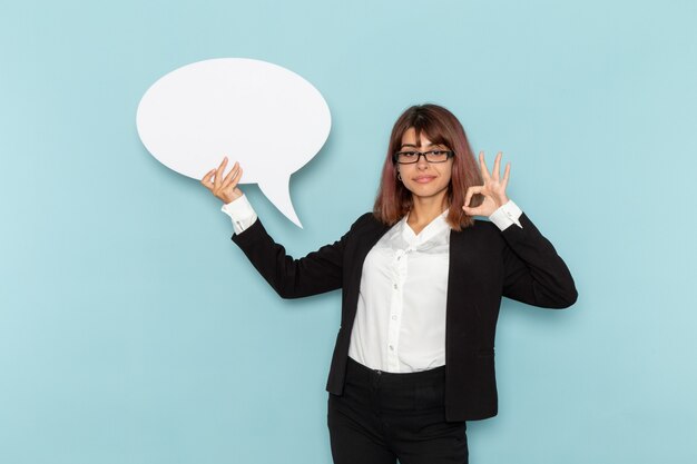 Front view female office worker holding big white sign on the blue desk