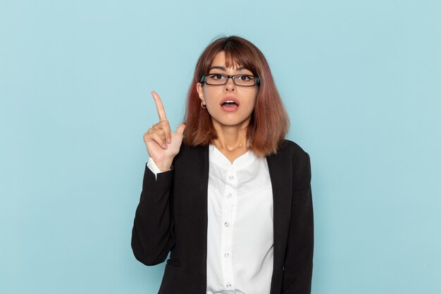 Front view female office worker raising her finger on the blue surface