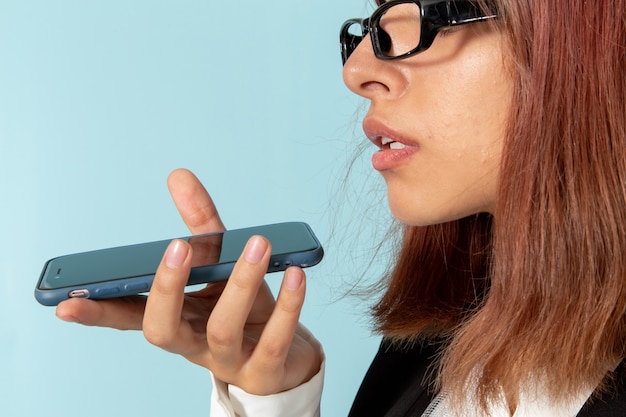 Free photo front view female office worker in strict suit talking on the phone on blue surface