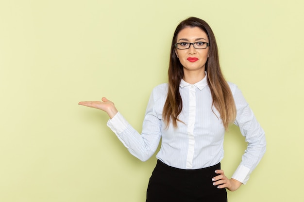 Free photo front view of female office worker in white shirt and black skirt smiling and posing on green wall