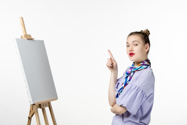 白い背景に絵を描くためのイーゼルを持つ女性画家の正面図アート フォト アーティスト ペイント ドロー絵タッセル