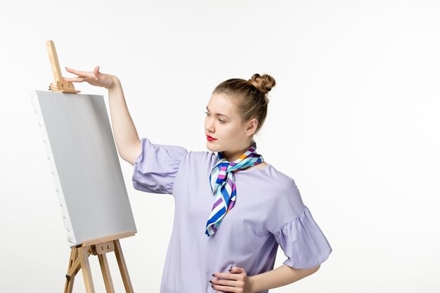 Front view female painter with easel for painting on white wall woman photo artist drawing art exhibition