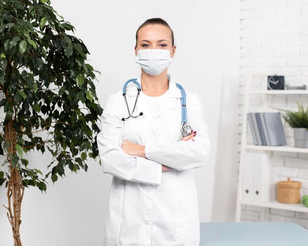 Front view of female physiotherapist with medical mask and stethoscope