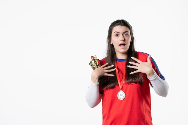 メダルと金のカップとスポーツ服の正面の女性