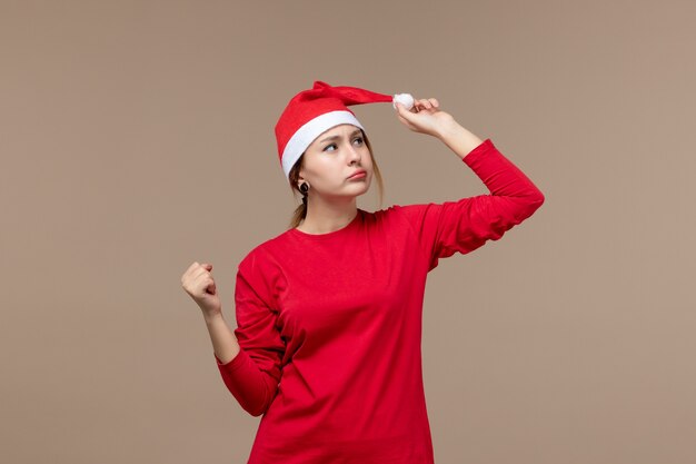 Front view of female in red thinking on brown