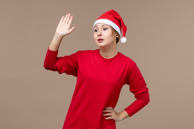 Front view of female in red waving at someone on brown