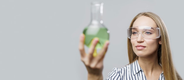 Free photo front view of female scientist holding test tube with copy space