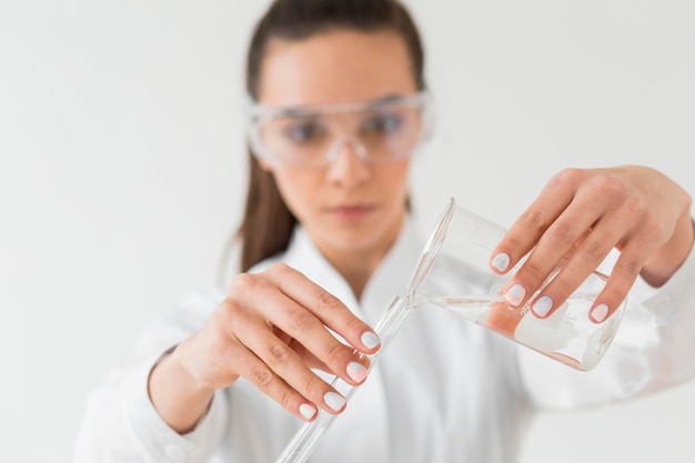 Front view of female scientist with safety glasses and potions