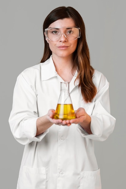 安全メガネと試験管を持つ女性科学者の正面図