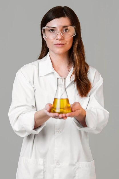 Front view of female scientist with safety glasses and test tube