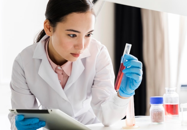 Front view of female scientist with substance and tablet