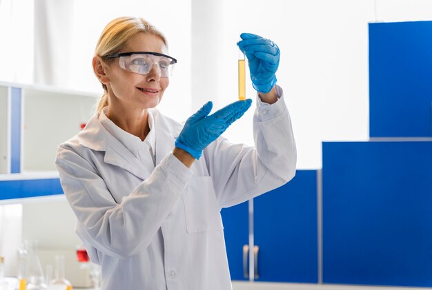 Front view of female scientist with surgical gloves looking at substance