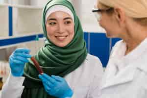 Free photo front view of female scientists in the lab analyzing substance