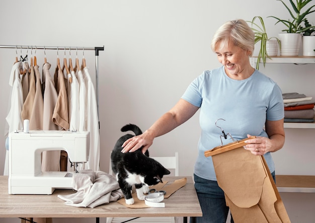 Free photo front view of female seamstress in the studio with cat