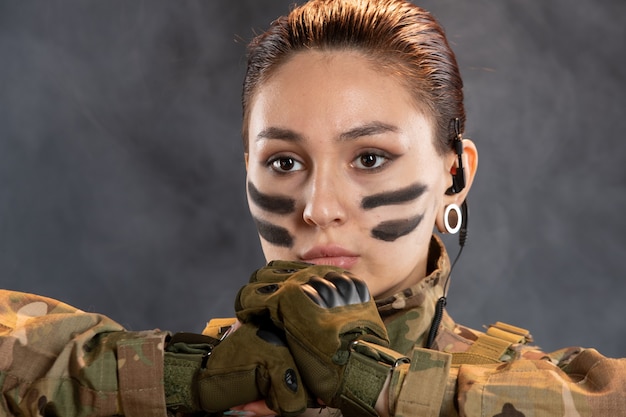 Free photo front view of female soldier in camouflage on dark wall