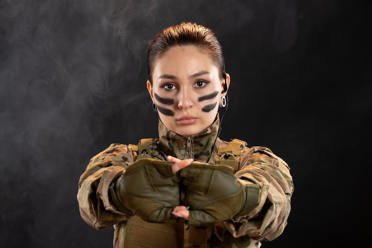 無料Photo 暗い壁にカモフラージュで女性兵士の正面図