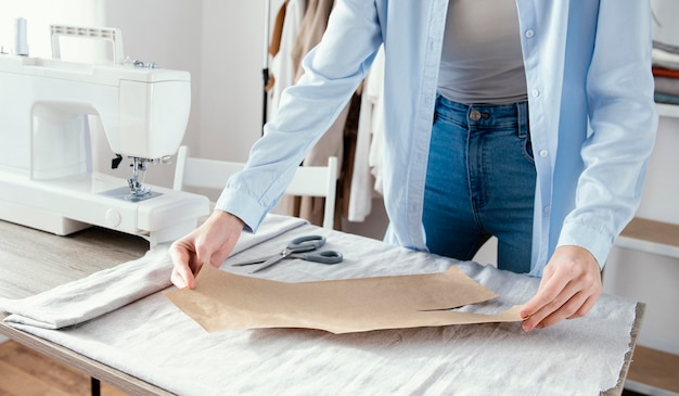 Foto gratuita vista frontale del sarto femminile che prepara tessuto per indumenti