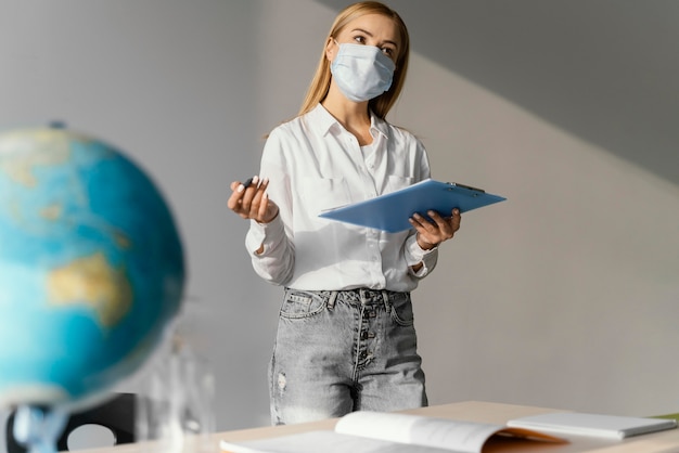 Vista frontale dell'insegnante femminile in aula con appunti