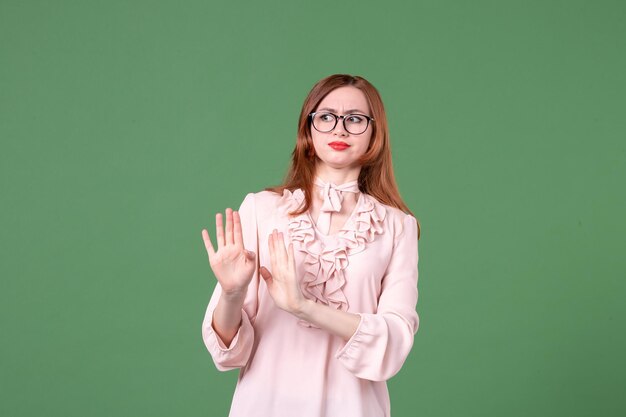 Front view female teacher in pink blouse on green background book student school college color work library woman young lesson