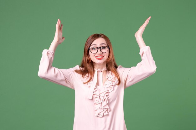 Front view female teacher in pink blouse on green background library college lesson color work book job young woman student