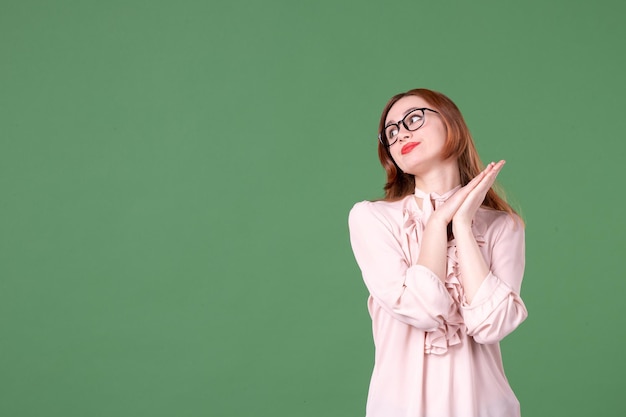 Vista frontale insegnante femminile in camicetta rosa su sfondo verde scuola colore biblioteca college lavoro studente giovane libro lezione lavoro donna