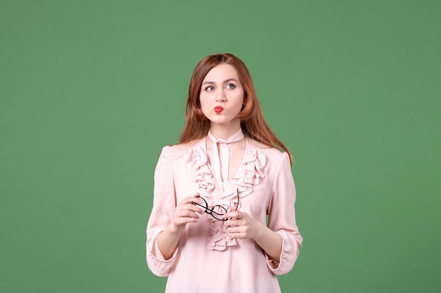 Front view female teacher in pink blouse on green background school library college lesson work book student young woman color