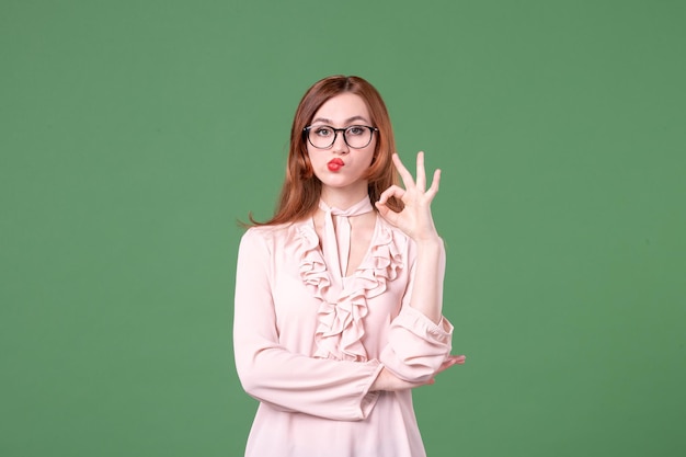 Front view female teacher in pink blouse on green background school library college lesson work job woman color student young books