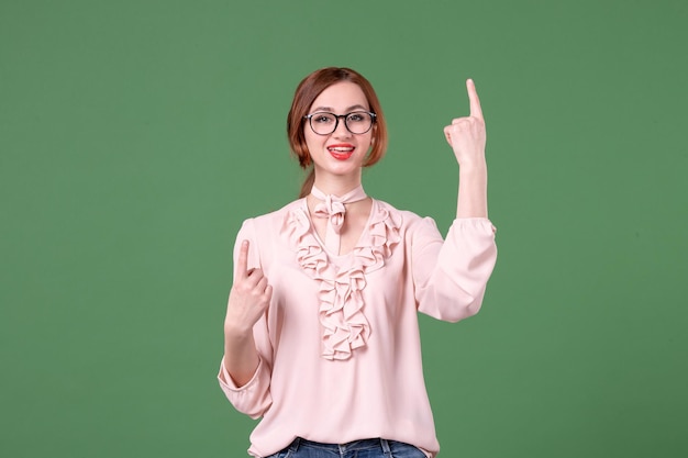 Free photo front view female teacher in pink blouse on green background student school college lesson color book young woman