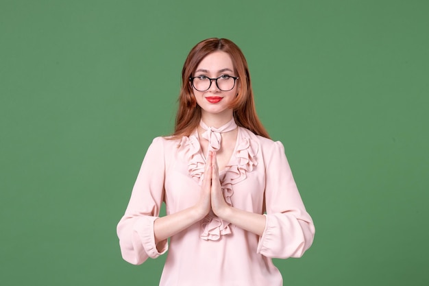 Front view female teacher in pink blouse posing on green background student job school young book woman work college color lesson