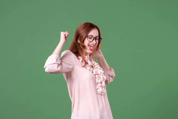 Front view female teacher in pink blouse rejoicing on green
