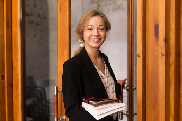 Front view female teacher with stack of books