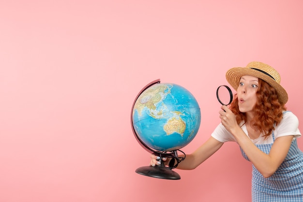 Free photo front view female tourist exploring globe with magnifier