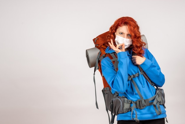 Front view female tourist going in mountain trip in mask with backpack