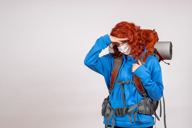 Front view female tourist going in mountain trip in mask with backpack