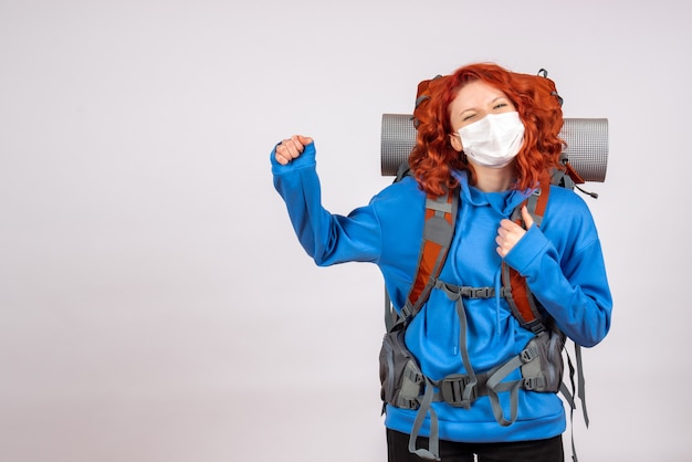 Free photo front view female tourist going in mountain trip in mask with backpack