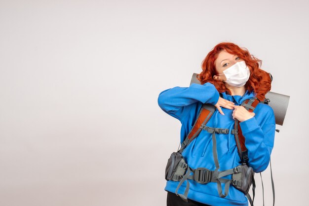 Front view female tourist going in mountain trip in mask with backpack