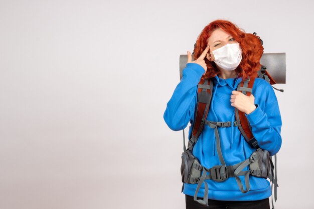 Front view female tourist going in mountain trip in mask with backpack