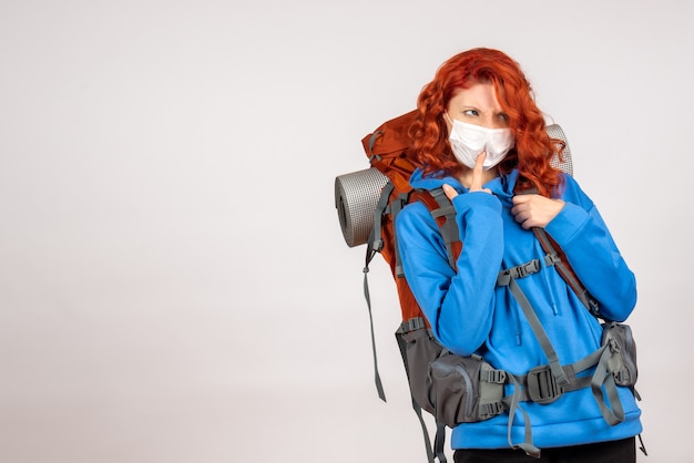 Front view female tourist going in mountain trip in mask with backpack