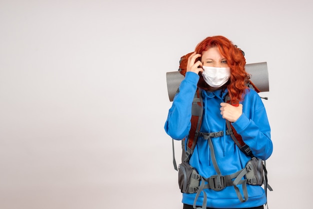 Front view female tourist going in mountain trip in mask with backpack