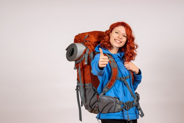 Front view female tourist going in mountain trip with backpack smiling