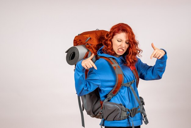 Front view female tourist going in mountain trip with backpack