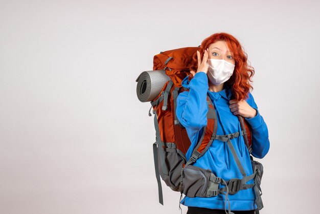 Front view female tourist going in mountain trip with backpack