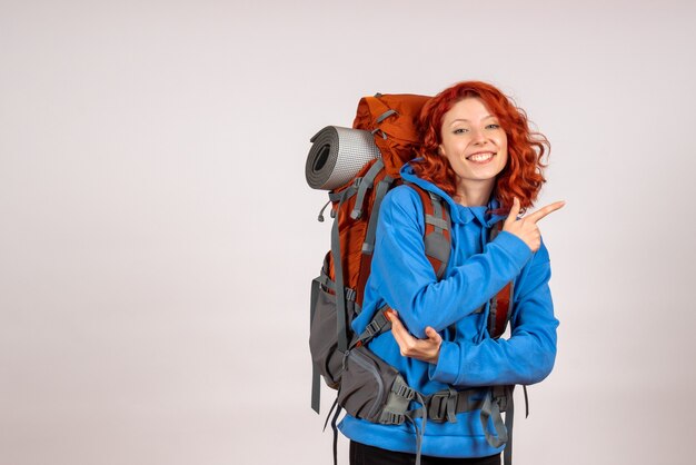 Front view female tourist going in mountain trip with backpack