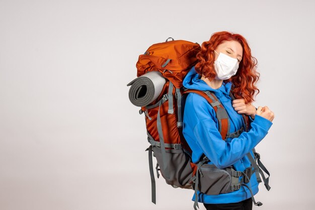 Front view female tourist going in mountain trip with backpack