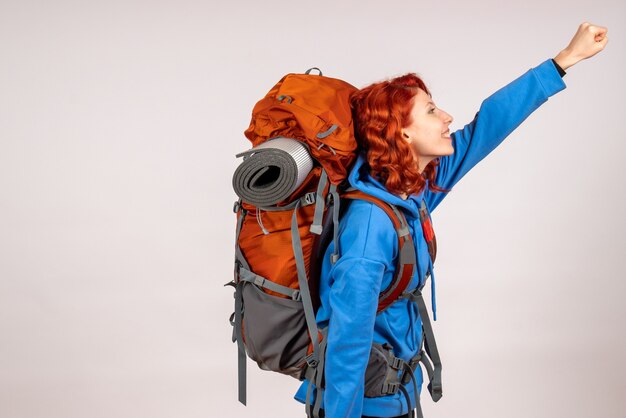 Front view female tourist going in mountain trip with backpack