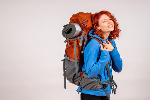 Front view female tourist going in mountain trip with backpack