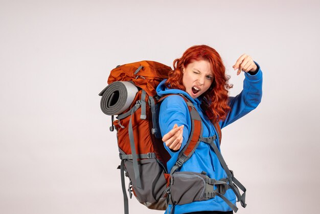 Front view female tourist going in mountain trip with backpack